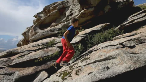 Kid climbing up the rock mountain Stock Footage 65829165