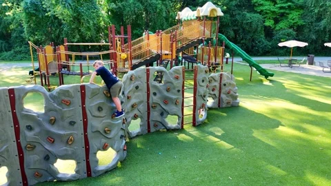 Kid climbing rock wall at Prairie Creek Park playground in Brownstown Video stock 327829486