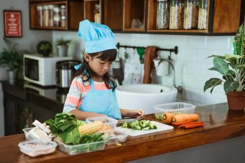 Kid cooking in the kitchen Stock Photos