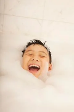 Kid Covered in Bubbles in Bubble Bath Stock Photos