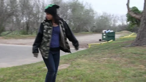 Kid with creepy mask pulled up walks thru park Stock Footage 155490628