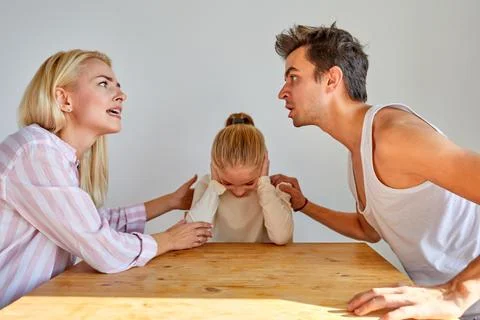 Kid daughter feeling upset while parents are quarrelling Stock Photos