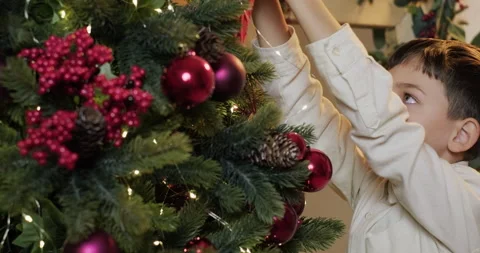 A kid is decorating Christmas tree Stock Footage 221812920