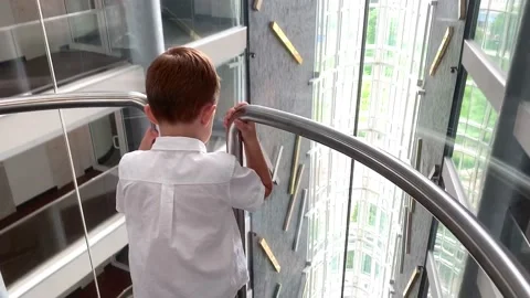 Kid descends on a glass elevator, view from the back 스톡 동영상 155169913