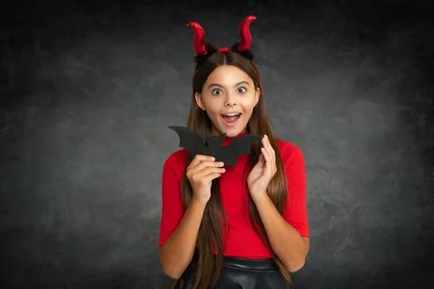 Kid with devil horns hold bat symbol of Halloween Halloween witch teen girl Foto stock