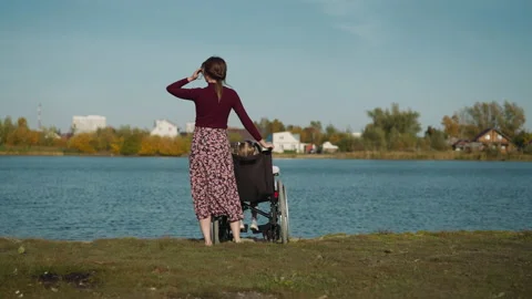 Kid with disability spends time with mother on river bank Stock-Footage 237717077