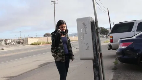 Kid discovers a pay phone Stock Footage 155385655