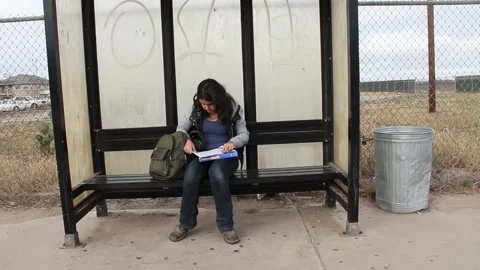 Kid does homework while waiting for bus Stock Footage 155488063