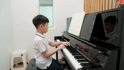 Kid doing piano exam Stock Footage 201725881