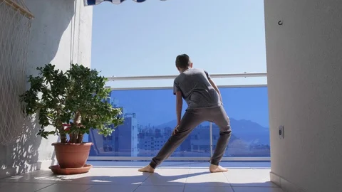Kid doing sport exercises, running, jogging in balcony. Active leisure at home Stock Footage 128942617