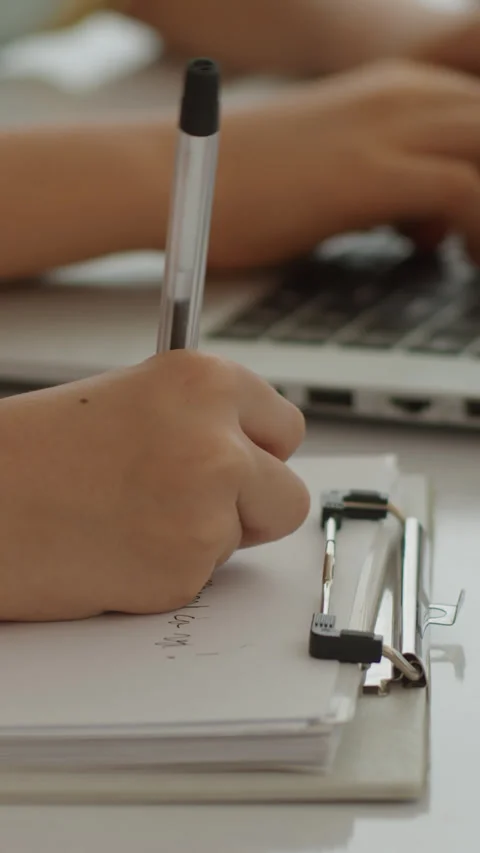 Kid Doing Test on Paper while His Friend Learning to Code on Laptop Stock Footage 280638309