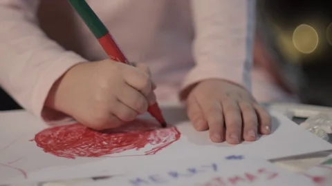 Kid is Drawing With Red Marker Christmas Lights Decoration is on Background New Stock Footage 71632653