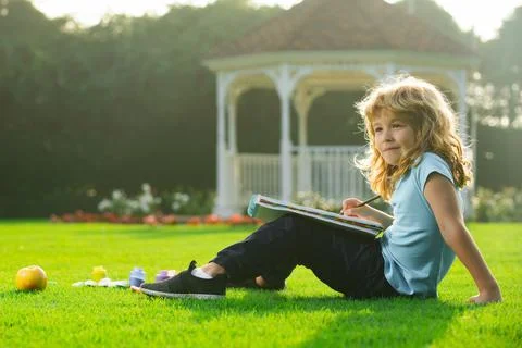 Kid draws in park having fun on nature background. Children creative, developing Stock Photos