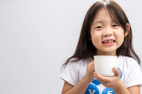 Kid drinking milk on studio isolated white background. Stock Photos