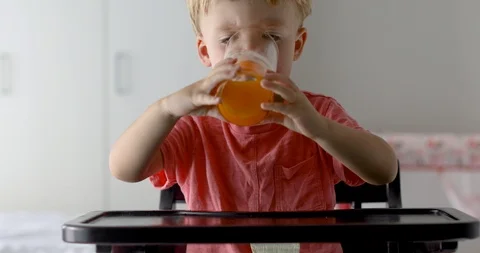 Kid drinking orange juice at home Video stock 101819082