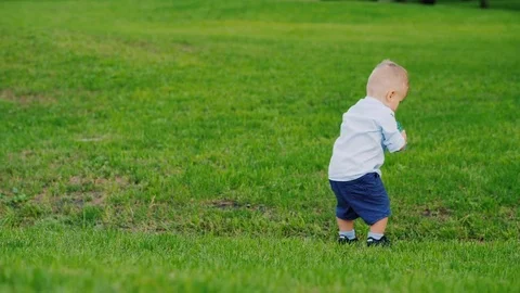 The kid drinks water from the bottle, then falls funny. Funny videos with Stock Footage 80050087