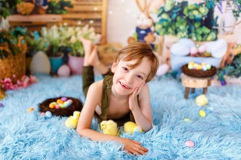 Kid on Easter egg hunt. Smiling kid with easter chiks. Stock Photos