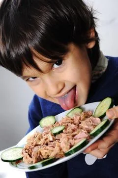 Kid eating fish Stock Photos