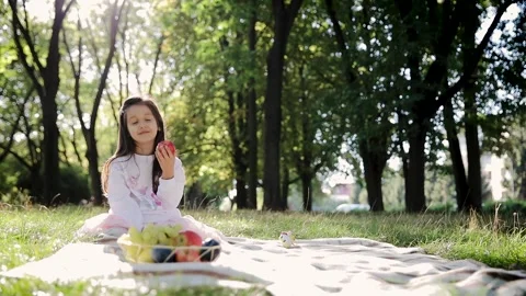 Kid eating fruit. Cute little girl eating red apple. Child bites fruit Stock Footage 263307241