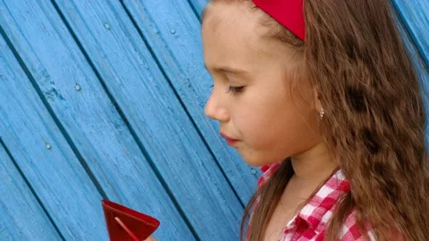 Kid eats and licks a lollipop, enjoying the taste of candy. Stock Footage 169322760