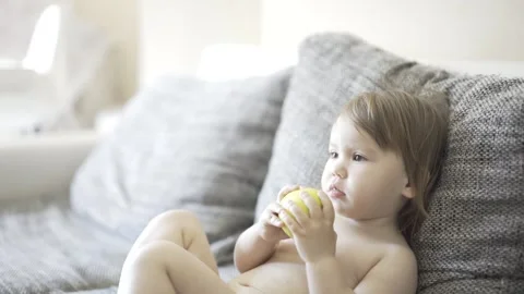 The kid eats an apple. A little child holds a green apple in his hands Stock Footage 240320006