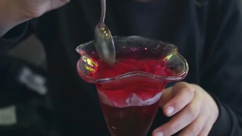 Kid eats delicious jelly from a beautiful glass Stock Footage 104779851