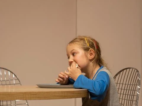 Kid eats flatbread cheese roll in kitchen. Child having dinner. Homemade heal Stock Photos
