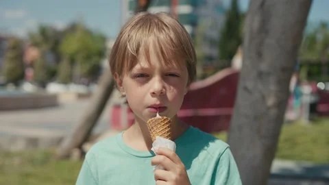 Kid eats ice-cream. Young boy child eating icecream dessert Stock Footage 196568690