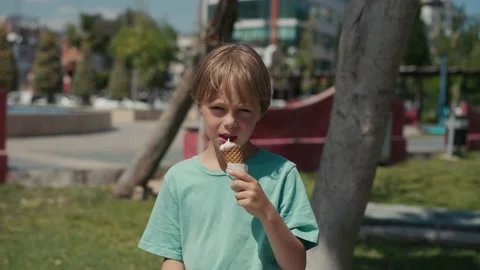 Kid eats ice-cream. Young boy child eating icecream dessert Vidéo 196980564