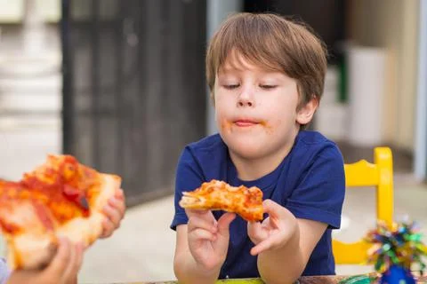 A kid eats a pizza. Stock Photos