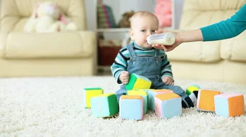 Kid eats porridge sitting on the floor Video stock 10687867