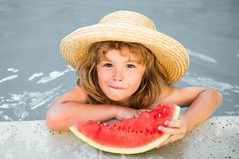Kid eats watermelon in the pool. Cute boy eating slice of red watermelon on the Stock Photos
