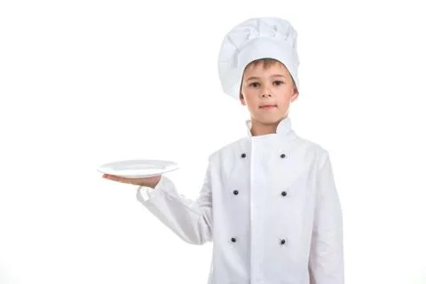 A kid with an empty plate wearing chef uniform on white background. Stock Photos