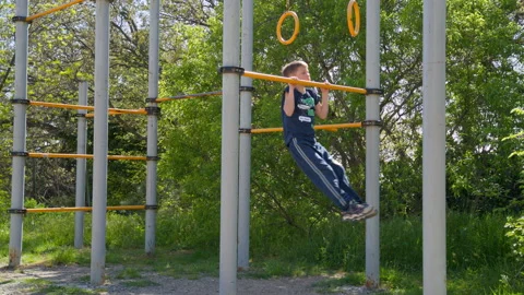 Kid exercising on street workout bar, childhood fitness and active lifestyle Stock Footage 308032344