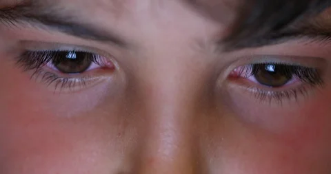 Kid eyes staring at screen light at night. Boy addicted to electronic watchin Stock Footage 128726488