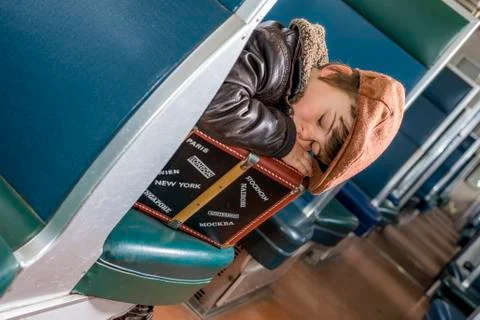 Kid fell asleep on his suitcase in a train Stock Photos