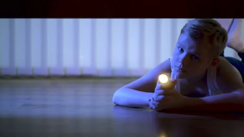 The kid with a flashlight looking under the bed. evening night time Stock Footage 90012186
