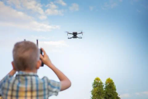 Kid flying drone. Boy operate drones Stock Photos