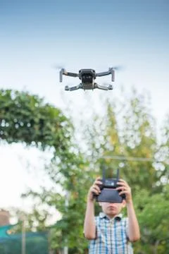 Kid flying drone. Boy operate drones Stock Photos