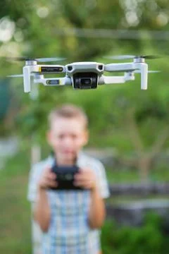 Kid flying drone.  Boy operate drones. Child Operating Quadcopter. Little Pil Stock Photos