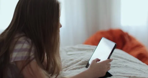 Kid girl in bed playing a tablet in social internet. Stock Footage 335643918