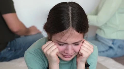 Kid girl crying while her parents are arguing on background. Parent's divorce Stock Footage 301372690