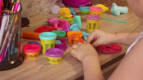 Kid girl playing with plasticine at home or kindergarten Stock Footage