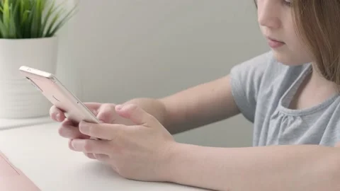 Kid girl using texting mobile phone or chat in home in the morning and sunlight Stock Footage 196301541