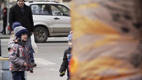 Kid in glasses running away from man in dinosaur costume at sidewalk Stock Footage 84930825