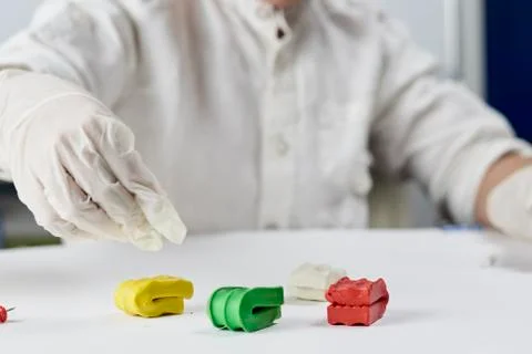A kid in gloves playing with plasticine Stock Photos