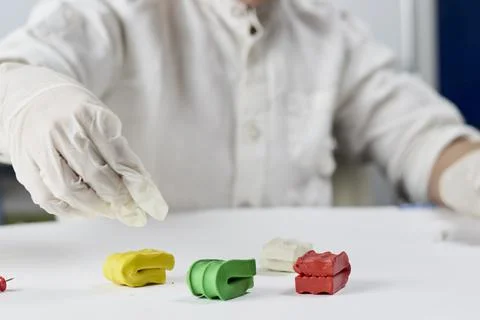 A kid in gloves playing with plasticine Stock Photos