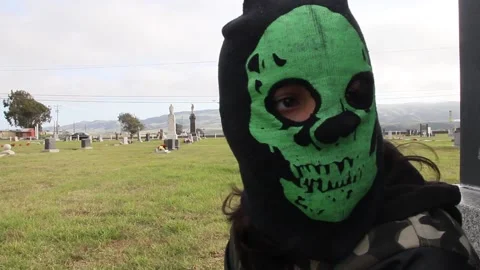 Kid in graveyard takes off mask Stock Footage 155327550