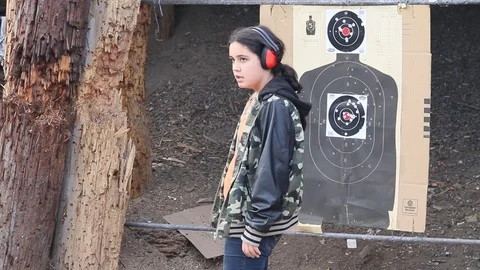 Kid at gun range moving safety cone Stock Footage 113911110
