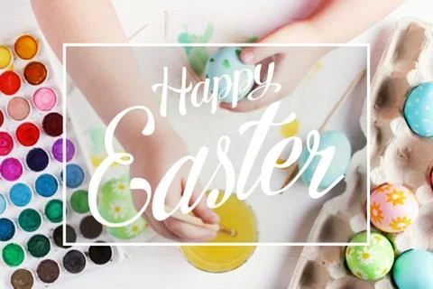 Kid hand painted boiled Easter eggs, paints and brushes on a white table. Pre Stock Photos